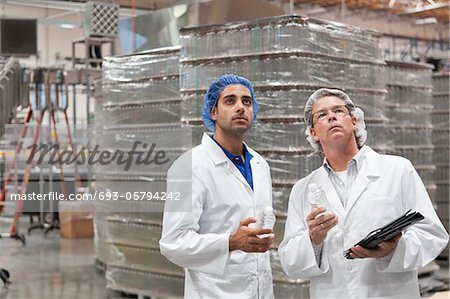 Quality control workers inspecting at bottling plant