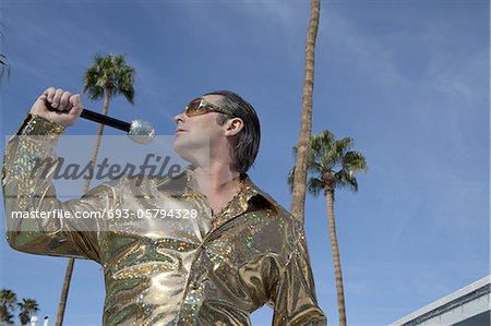 Profile view of middle-aged man posing with microphone
