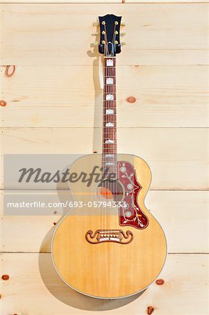 Acoustic guitar with label on a wood grain wall