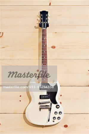 White guitar on wood grain wall