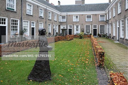 Eine Statue von einer Nonne befindet sich in einem Innenhof des historischen Gehäuses für Frauen am Begijnhof (Beginenhof), Breda, Nordbrabant, Niederlande, Europa