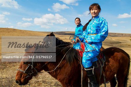 Junge mongolische Frauen in Tracht (Deel) Reiten Pferde, Provinz von Chowd, Mongolei, Zentralasien, Asien