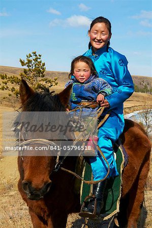 Young Mongolian woman and child in traditional costume (deel) riding a horse, Province of Khovd, Mongolia, Central Asia, Asia