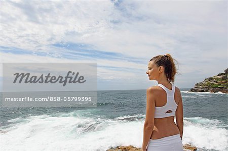 Jeune femme debout au bord de la mer