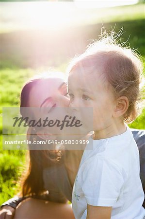 Mutter küssen Kleinkind im park