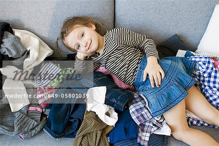 Smiling girl laying on pile of laundry