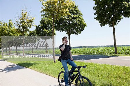 Man talking on cell phone on bicycle