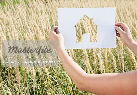 Woman holding paper house cut out