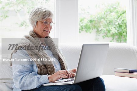 Sourire de femme plus âgée, à l'aide d'ordinateur portable