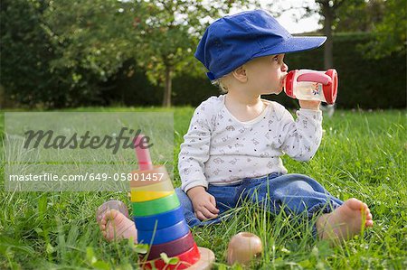 Baby drinking juice in grass