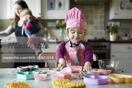 Toddler girl baking in kitchen