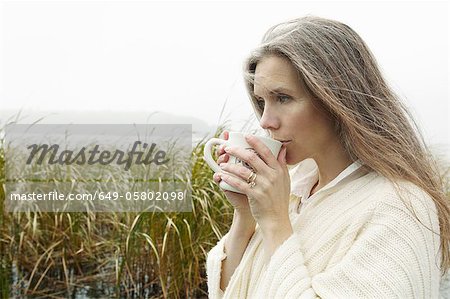 Older woman drinking coffee outdoors