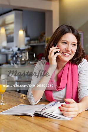 Woman talking on cell phone in cafe