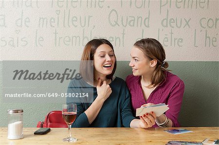 Women looking at photographs in cafe