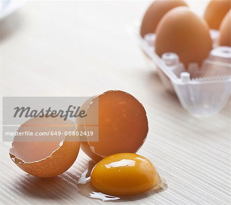 Gros plan du jaune de œuf et coquilles d'oeufs cassés Gros plan du jaune de œuf et coquilles d'oeufs cassés