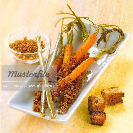 Carrots with their tops coated with honey and crumbled gingerbread