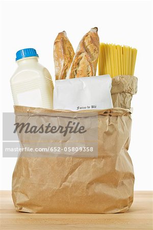 Cereal products and a bottle of milk in a brown paper bag