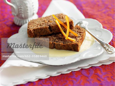 Slices of chocolate cake with custard and orange zests