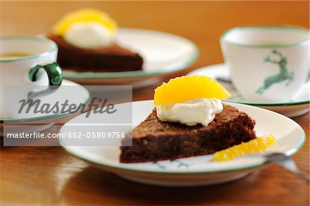 Tranche de gâteau au chocolat avec crème et frais orange