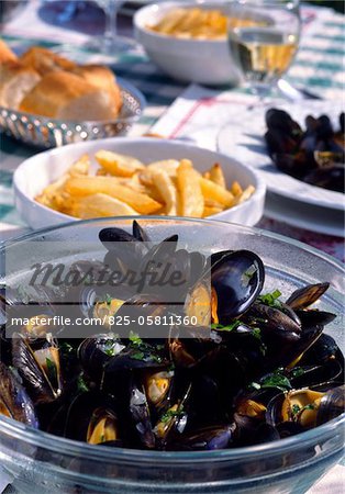 Mussels and chips on table outdoors