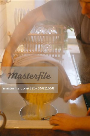 Tipping pasta into colander