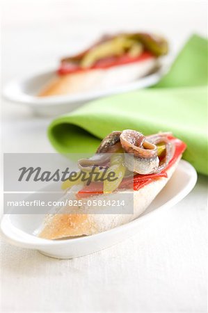 Anchois et poivrons sur une tranche de bouchées de pain Anchois et poivrons sur une tranche de bouchées de pain