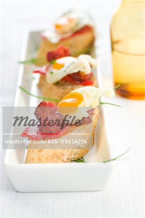 Oeufs caille frit et Chorizo sur une tranche de bouchées de pain Oeufs caille frit et Chorizo sur une tranche de bouchées de pain