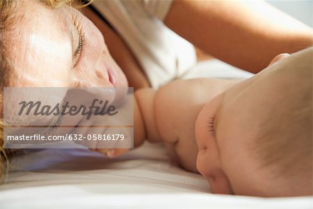 Mother lying down beside baby