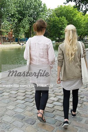 Young women walking together, rear view