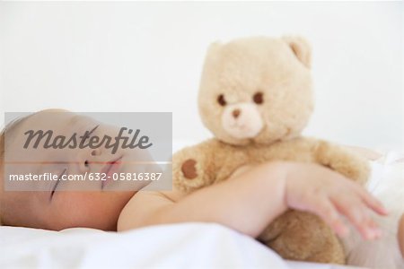 Bébé dort avec ours en peluche