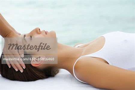 Young woman receiving head massage, side view