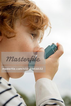 Boy using asthma inhaler