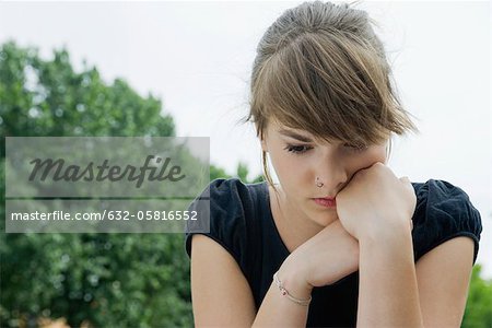 Jeune femme regardant vers le bas dans la pensée