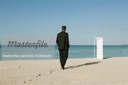 Kaufmann zu Fuß am Strand nach halb offene Tür im Hintergrund