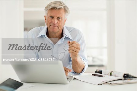 Alter Mann mit Laptopcomputer zu Hause