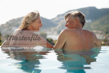 Mature couple détente ensemble dans la piscine, vue arrière