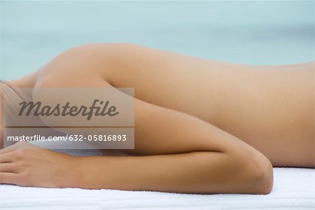 Topless femme couchée sur le ventre sur la table de massage, moyenne section