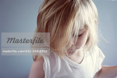 Petite fille regardant vers le bas, cheveux couvrant le visage