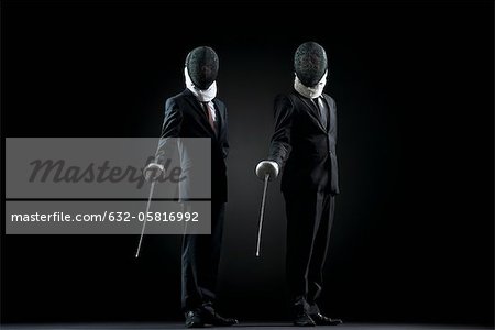 Les hommes d'affaires permanent avec feuilles et masques d'escrime