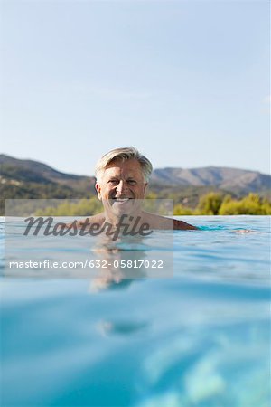 Homme Senior relaxant dans la piscine, portrait