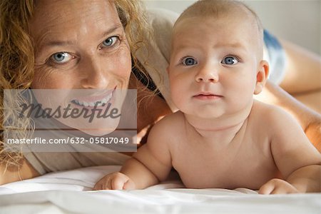 Mother lying down beside baby, portrait