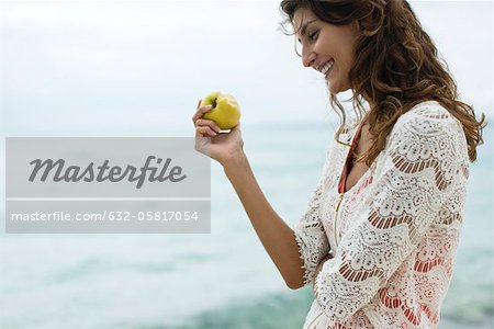 Woman eating apple at the beach