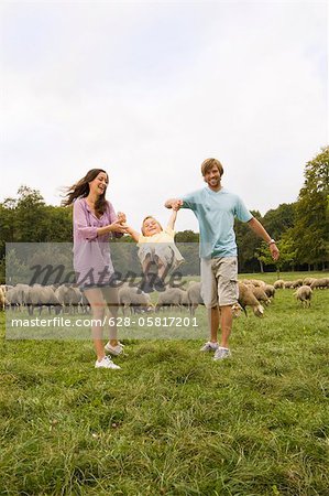 Family and flock of sheep in meadow, Munich, Bavaria, Germany