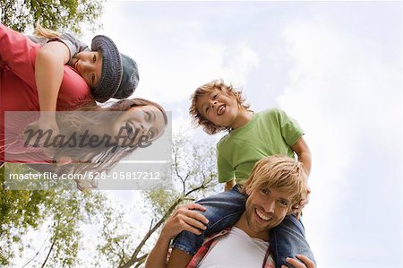 Parents carrying their children piggyback, Munich, Bavaria, Germany