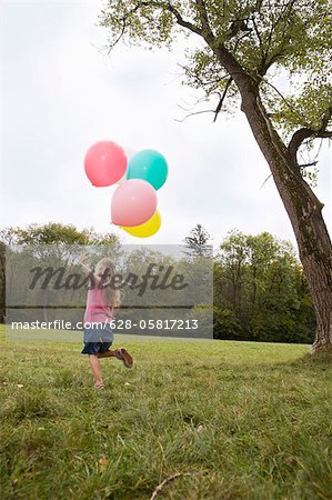 Mädchen laufen auf der Wiese mit Luftballons, München, Bayern, Deutschland