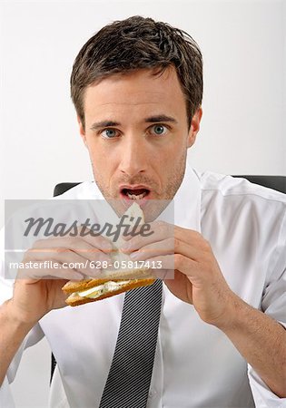 Businessman is eating a sandwich