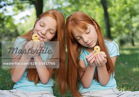 Red haired twins holding chicks