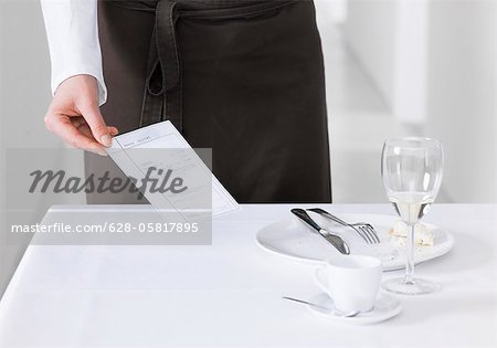 Waitress bringing bill to table