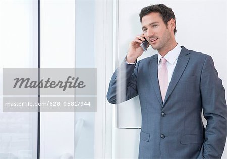 Homme d'affaires à l'aide de téléphone portable sur le plancher de bureau