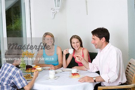 Familie trinken Kaffee und essen Kuchen auf der Terrasse, München, Bayern, Deutschland